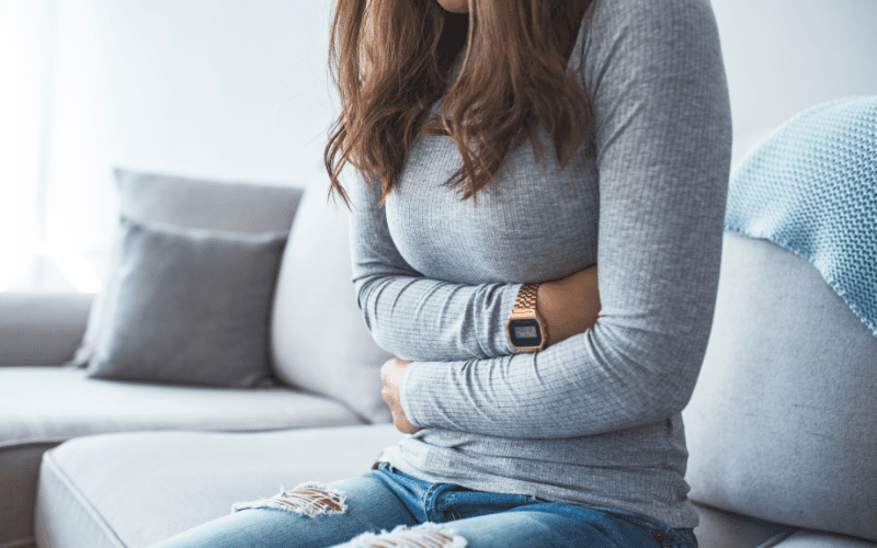 woman holding stomach with stress and IBS