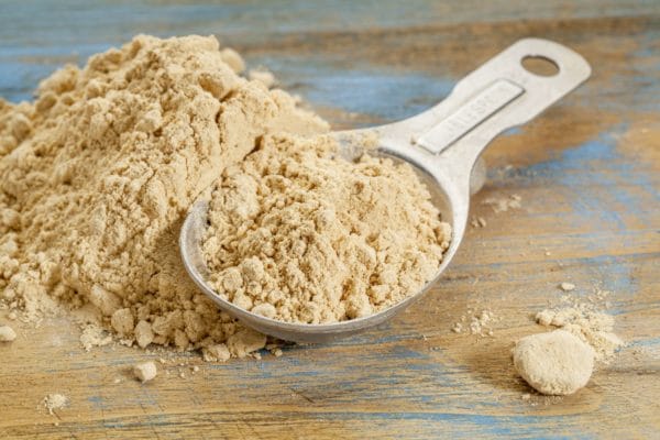 spoon with pile of maca powder